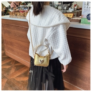 Detail of a kids gold heart bag with crocodile pattern and stylish chain strap