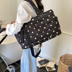 Quilted black mommy bag with gold polka dots and adjustable strap for strollers