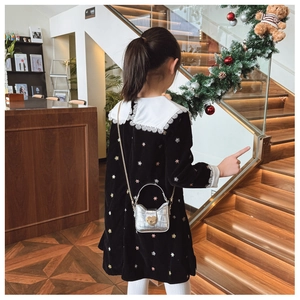 Rear view of velvet girl's dress with white lace collar and heart-shaped crossbody bag