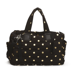 Quilted black tote bag with gold polka dots and adjustable shoulder strap for travel