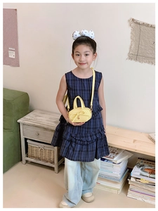 Close-up of yellow mini crossbody bag for kids featuring a decorative sweet bow detail