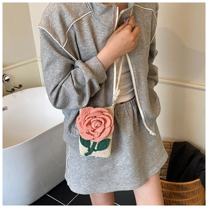 Texture détaillée du sac à bandoulière beige tricoté main avec rose rose et feuilles
