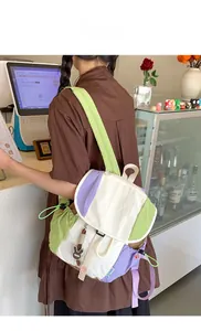 Détail du sac à dos en toile color-block avec cordon de serrage et charm de lapin mignon