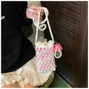 Detail of handmade crochet shoulder bag with pink tulip patterns and wooden button closure
