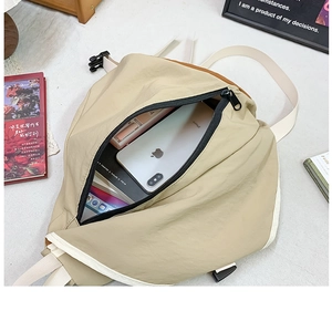 Detail showing the internal storage capacity for phone and books in a nylon chest bag