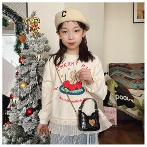 Detail of a white cherry pie sweatshirt with mesh lace hem and heart crossbody bag
