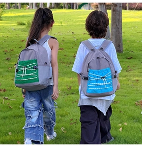 Kids sports backpacks in grey with contrast pockets shown during outdoor hiking activity