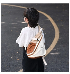 Detail of color-block canvas chest bag with adjustable strap and KLTS logo on kid's back