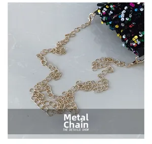 Detail of golden metal chain and colorful shimmering sequins on a stylish bucket bag