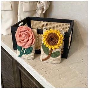 Détail du crochet 3D avec tournesol et rose sur un petit sac à bandoulière tressé à la main