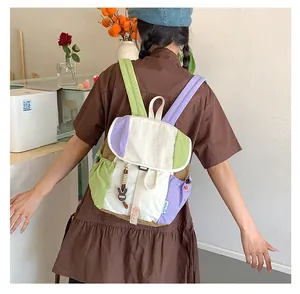 Détail du sac à dos color-block avec fermeture à cordon et breloque lapin tendance