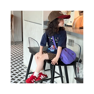 Detail of child wearing a purple nylon crossbody bag with adjustable wide strap for kids