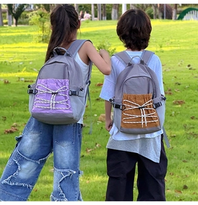 Detail of two durable school backpacks with contrast color pockets and bungee cord design