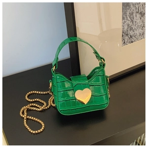 Close-up of green crocodile texture mini bag with large gold heart-shaped metal buckle
