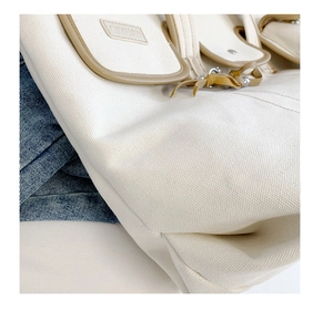Close-up of durable canvas shoulder bag with khaki leather pocket and QIYUAN logo tag