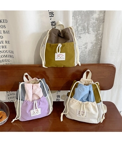 Dettaglio di zaini in tela colorata con coulisse, tasche laterali a rete ed etichette logo