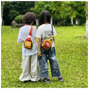 Detailed outdoor view of colorful color-block kids crossbody bag with mountain logo patch
