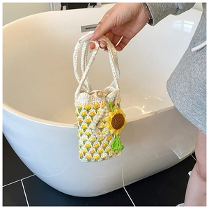 Detail of crochet crossbody bag with yellow tulips, wood button and floral charms