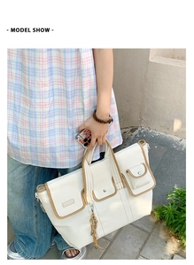 Detail of white canvas tote bag with brown leather trim and multiple functional pockets