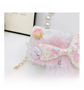 Détail du nœud en paillettes roses et perles sur un sac à paillettes blanc pour fille
