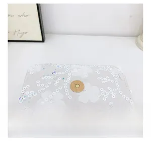 Détail de fleurs à paillettes blanches et fermoir magnétique doré sur sac enfant