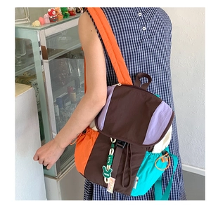 Détail d'un sac à dos patchwork coloré avec poche latérale à cordon et porte-clé lapin