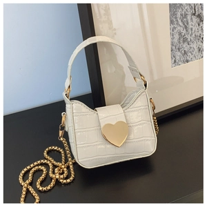 Close-up of white crocodile pattern leather mini bag with golden heart clasp and chain strap