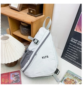 Detail of a white and grey kids chest bag with KLTS logo and adjustable strap