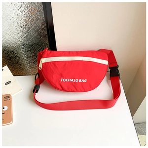 Detail der roten Kindertasche mit weißem Buchstabendruck und Nylon-Schultergurt