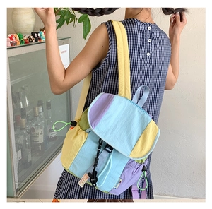 Détail d'un sac à dos en nylon multicolore avec poches à cordon et fermeture à boucle