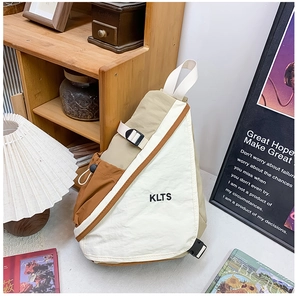Detailed view of the tri-color patchwork chest bag featuring neutral tones and KLTS logo