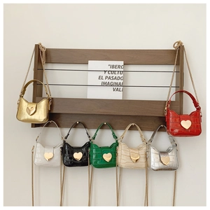 Close-up of mini kids shoulder bags with stone pattern texture and gold heart buckles