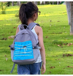 Detail of grey and blue kids school backpack with front bungee cord and mesh side pocket