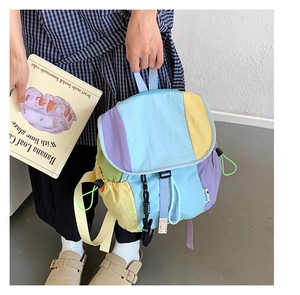 Détails du sac à dos bicolore montrant la fermeture à cordon et le patchwork pastel