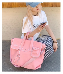 Pink canvas tote bag with adjustable shoulder strap and utility pockets for daily commute