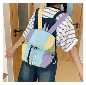 Détail d'un sac à dos patchwork aux couleurs macaron avec fermeture par boucle