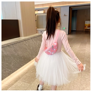 Détail d'un sac banane rose en toile avec motifs licornes porté en bandoulière enfant