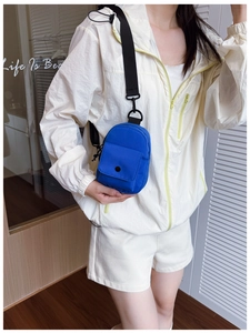 Blue mini nylon chest bag for kids with black wide strap shown on child model