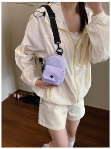 Detailed view of lavender nylon mini crossbody chest bag with adjustable black strap