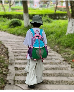 Detailed back view of a colorful drawstring backpack with heart-shaped mesh pocket detail