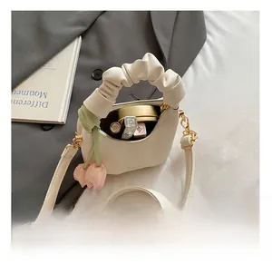 Detailed view of cream ruffled cloud bag with pink tulip charm and inner storage space