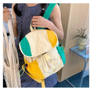 Détail d'un sac à dos en nylon coloré avec poches à cordon et bretelles jaunes