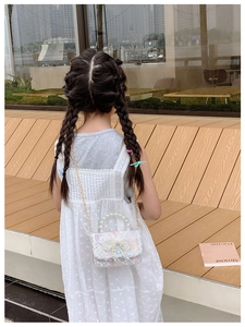 Vue arrière d'une fille portant un sac en dentelle blanche avec poignée en perles et chaîne