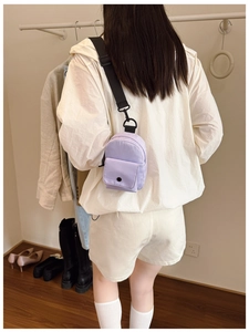 Detail view of mini purple nylon chest bag with adjustable black strap for kids