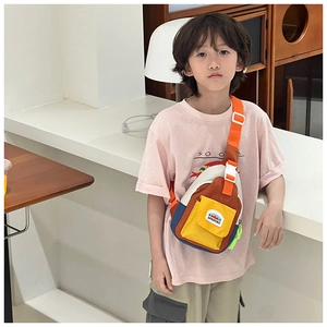 Kids color-block crossbody chest bag with adjustable strap worn by a child in a cafe