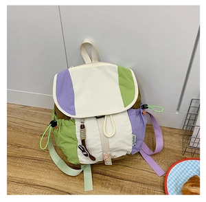 Détail d'un sac à dos color-block avec cordon de serrage, rabat et breloque lapin mignonne