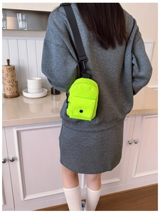 Modern neon green mini crossbody bag shown on model with adjustable black shoulder strap