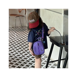 Close-up of bright purple shell crossbody bag with adjustable strap for kids