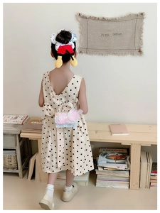 Détail du sac fille en dentelle rose avec poignée en perles et nœud porté par un enfant