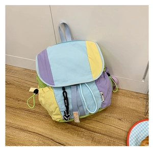 Détail d'un sac à dos patchwork aux couleurs pastel avec cordon et pendentif lapin